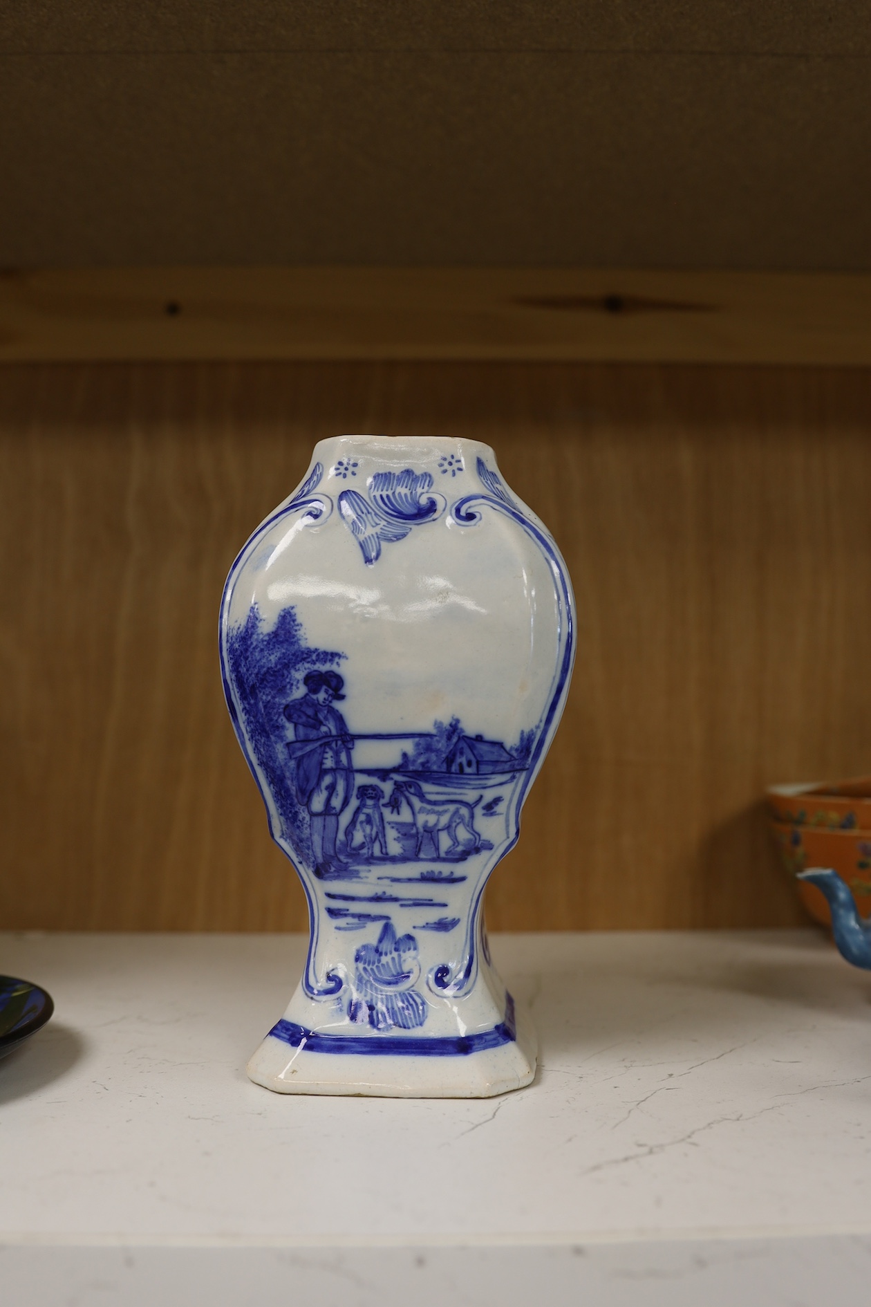 A 19th century Delft blue and white vase and a Watcombe Torquay pottery chamberstick, 19.5cm. Condition - both fair